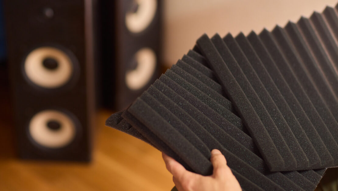 setting up audio equipment with soundproofing panels in a modern studio environment