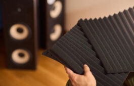 setting up audio equipment with soundproofing panels in a modern studio environment