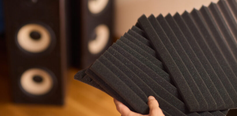 setting up audio equipment with soundproofing panels in a modern studio environment