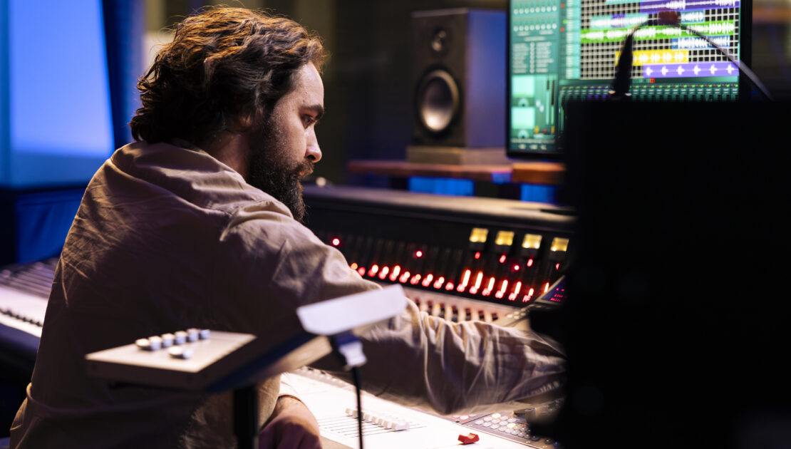 audio technician working on recording and editing new music in studio