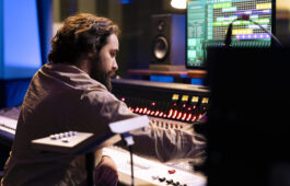 audio technician working on recording and editing new music in studio